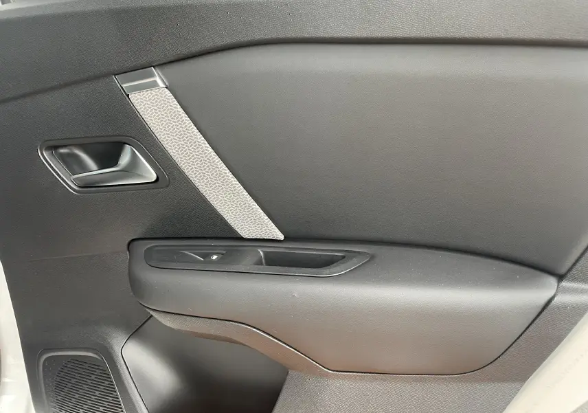 Gros plan sur la porte côté gauche intérieure noire avec insert gris clair d'une Citroën C4 blanche 2022.