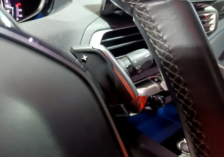 Gros plan sur le volant cuir noir et la commande de palette de changement de vitesse du Peugeot 3008 2022.