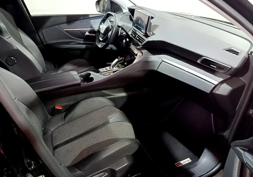 Intérieur avant droit du Peugeot 3008 noir, volant cuir multifonctions et écran tactile central visible.