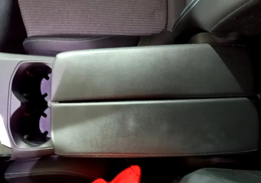 Vue plongeante sur l'accoudoir central en cuir noir et porte-gobelets du Peugeot 3008 noir, version Allure Pack 2022.