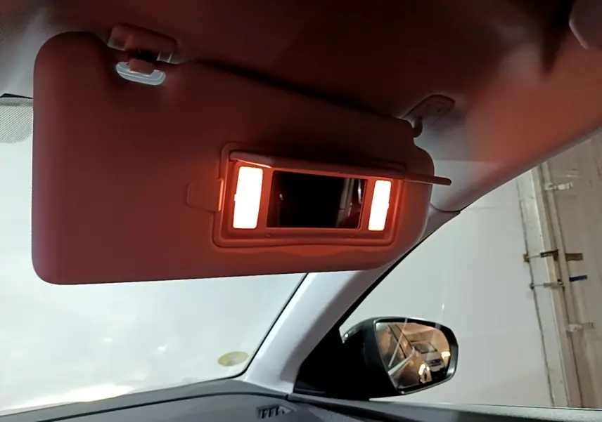 Vue intérieure du pare-soleil côté conducteur avec miroir éclairé dans un Peugeot 3008 noir de 2022.