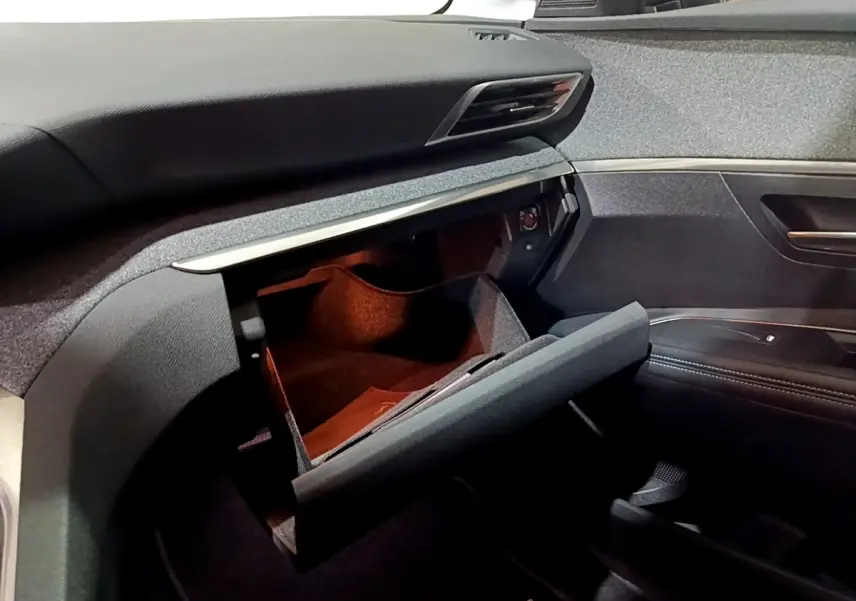 Vue intérieure côté passager du Peugeot 3008 noir 2022, avec boîte à gants ouverte et tableau de bord moderne.