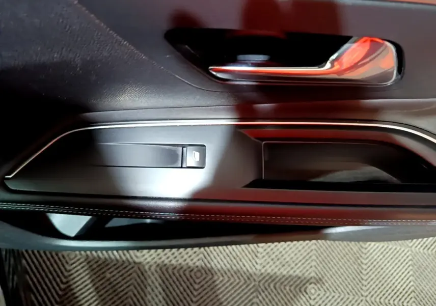 Détail de la poignée de porte intérieure noire avec commande de vitre sur le côté gauche du Peugeot 3008 2022.