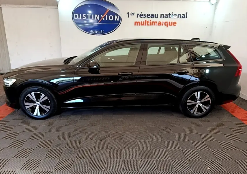 Profil côté gauche d’un break Volvo V60 noir 2020, avec jantes alliage et feux arrière LED visibles en intérieur showroom.