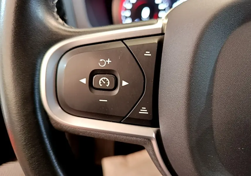 Gros plan sur les commandes de régulateur de vitesse au volant cuir noir du Volvo V60 D3 Business 2020.