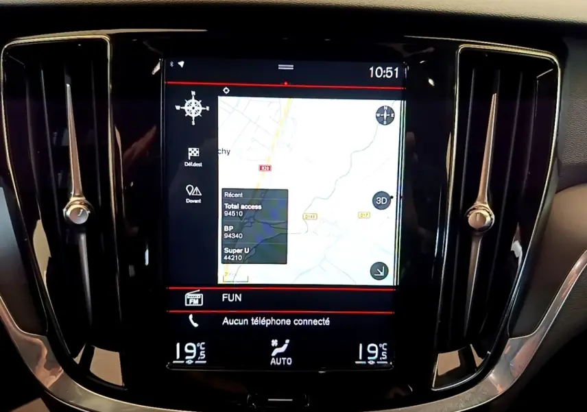 Écran tactile central du tableau de bord noir de la Volvo V60 2020 affichant la navigation 3D et la climatisation.