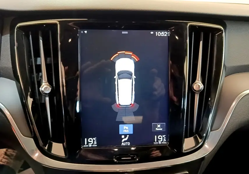 Vue rapprochée de l’écran tactile central noir du tableau de bord du Volvo V60 D3 Business 2020 affichant l’aide au stationnement.