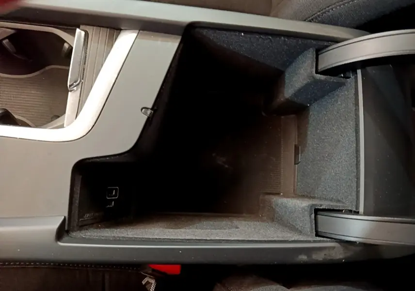Vue plongeante sur le rangement central noir intérieur de la Volvo V60 D3 AdBlue 2020 avec prise USB visible
