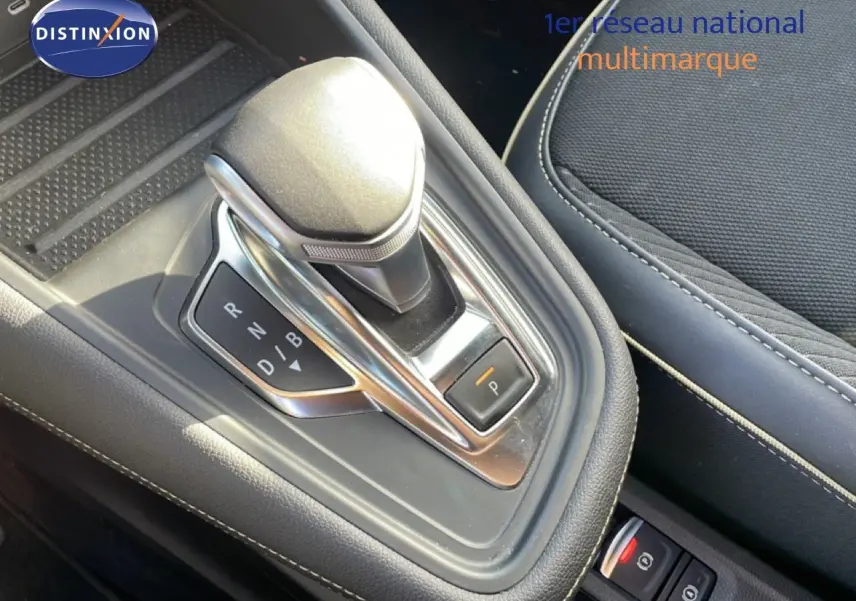 Gros plan sur le levier de vitesses automatique de la Renault Symbioz gris cassiopée, avec sellerie tissu noire visible.