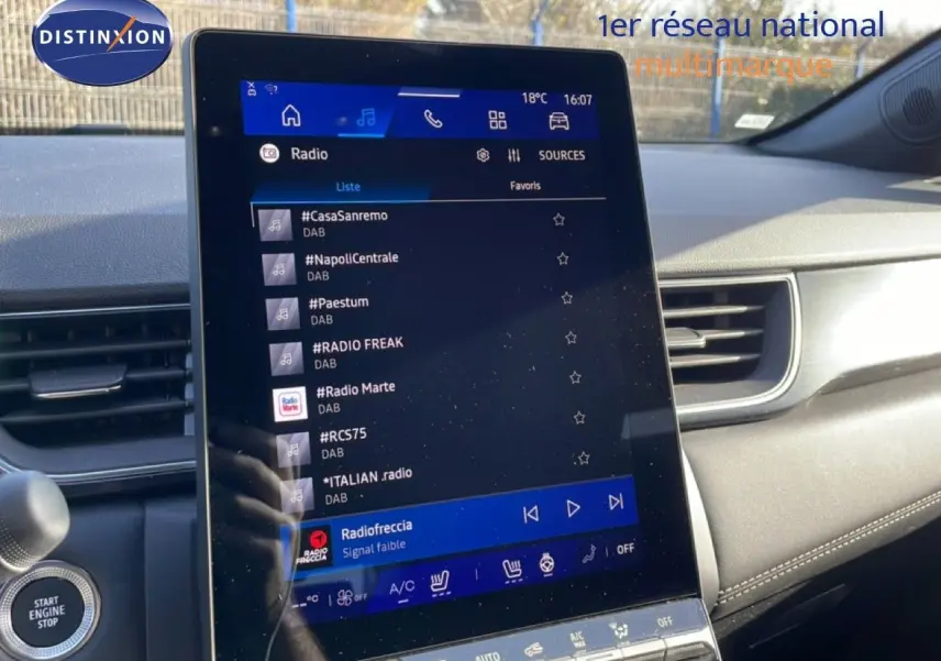 Vue intérieure du tableau de bord de la Renault Symbioz 2025, avec écran tactile central affichant les stations radio.