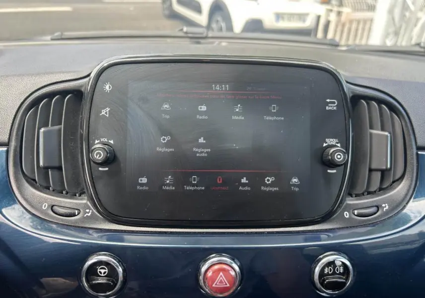 Tableau de bord bleu de la Fiat 500 2024 avec écran tactile central et commandes circulaires d’aération visibles.