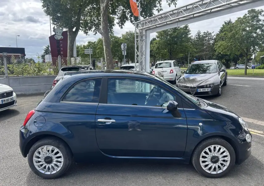 Profil côté gauche d'une FIAT 500 2024 bleu avec jantes alliage 16'' Spider, stationnée en extérieur.