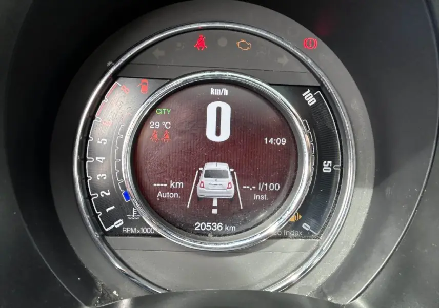 Tableau de bord circulaire du Fiat 500 2024 affichant la vitesse à zéro et un visuel arrière du véhicule en gris.