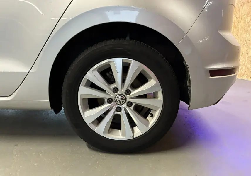 Gros plan sur la roue arrière droite d'une Volkswagen Golf Sportsvan gris métallisé avec jante alliage à dix branches.
