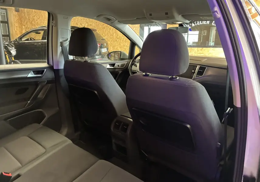 Vue intérieure arrière de la Volkswagen Golf Sportsvan 2019 gris, montrant les sièges avant et arrière en tissu gris noir.