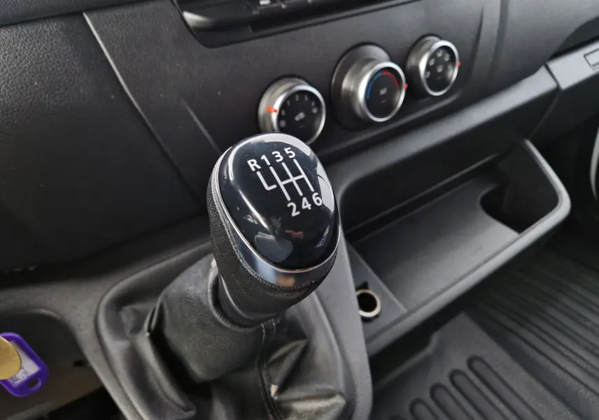 Gros plan sur le levier de vitesses manuel noir du Renault Master 2020, avec commandes de climatisation en arrière-plan.