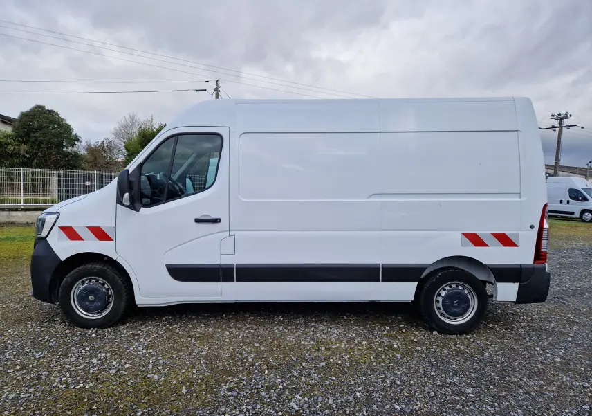 Vue de profil côté gauche d’un Renault Master blanc 2020 avec bandes réfléchissantes rouges sur les ailes avant et arrière.