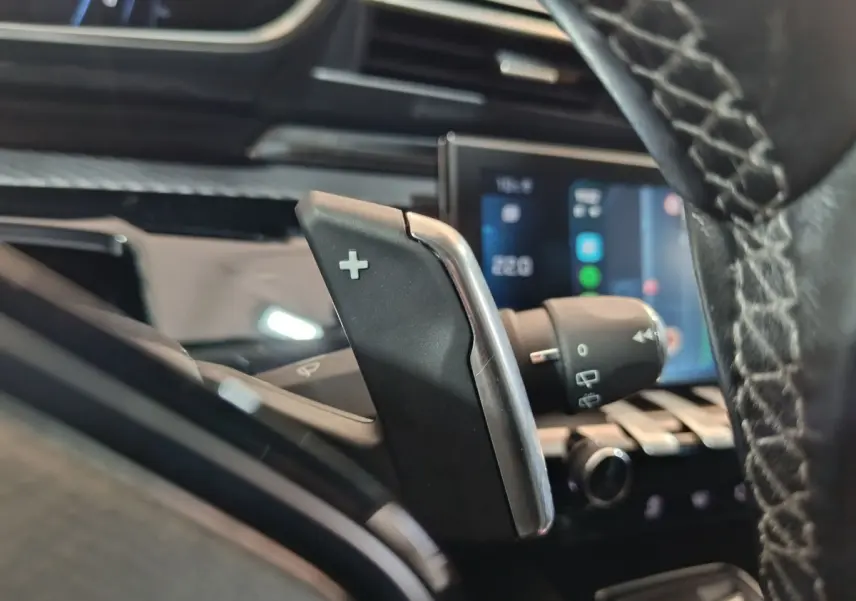 Gros plan sur la commande de palette de changement de vitesse droite dans l’habitacle noir du Peugeot 508 gris clair.