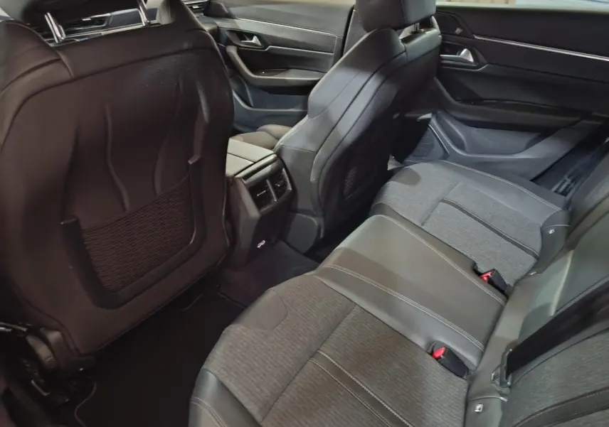 Vue intérieure arrière droit de la Peugeot 508 BlueHDi 130 Allure, sièges gris cuir et tissu avec console centrale et aérateurs.
