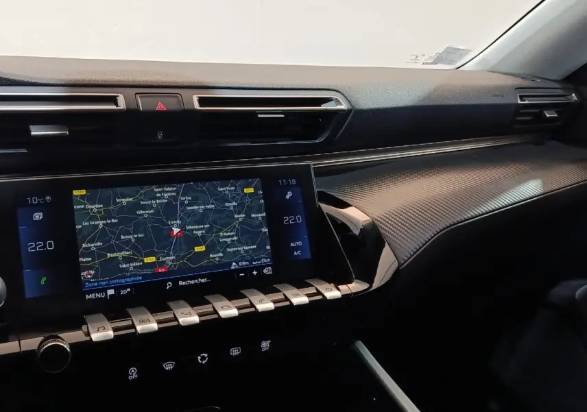 Vue intérieure du tableau de bord de la Peugeot 508 gris clair, avec écran tactile de navigation et commandes piano.