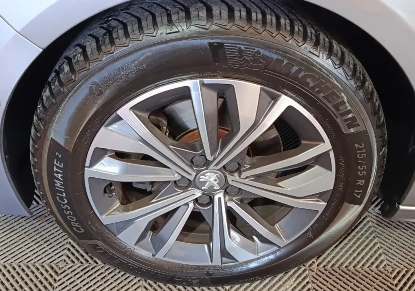 Gros plan sur la roue avant droite gris clair de la Peugeot 508 avec jante alliage et pneu Michelin CrossClimate 2.