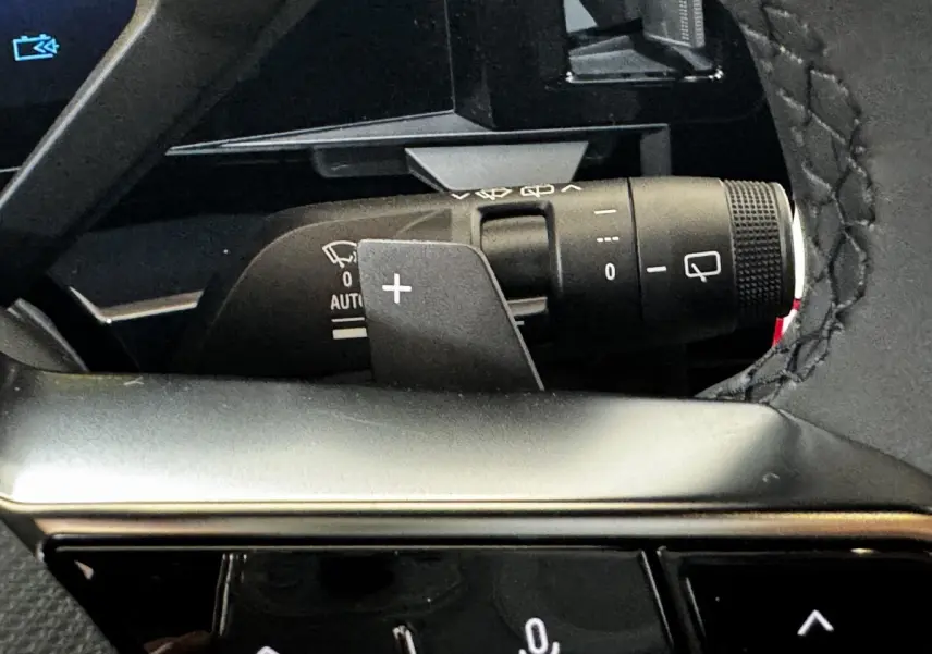 Gros plan sur la commande de clignotants et essuie-glaces du Renault Espace noir, intérieur avec volant cuir surpiqué.