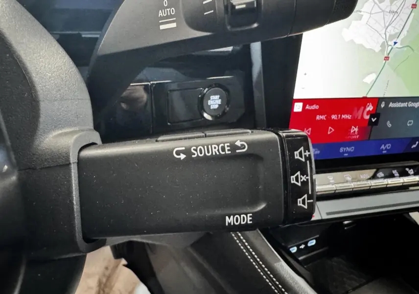 Détail intérieur du levier multifonction noir avec commandes audio et écran tactile de navigation du Renault Espace 2025.
