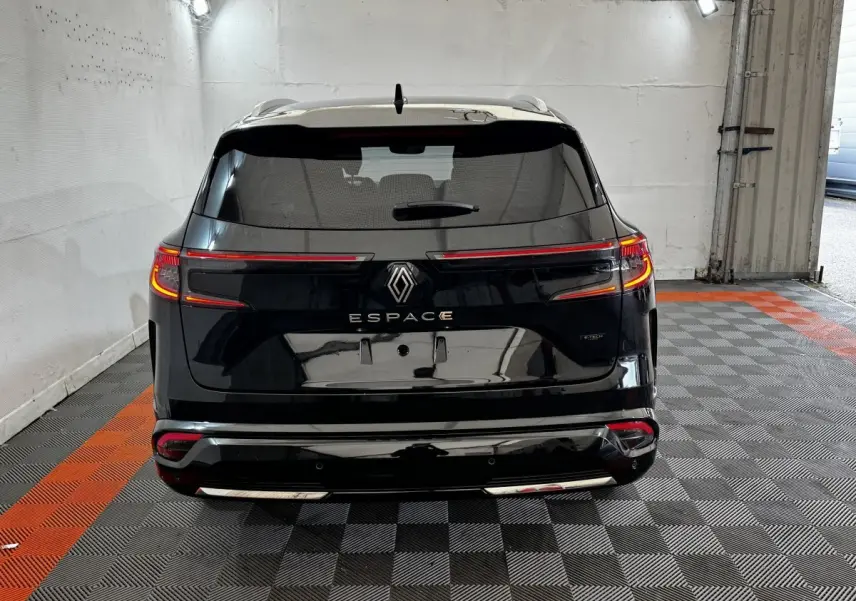 Vue arrière d'un Renault Espace noir 2025 avec feux LED allumés et rails de toit chromés dans un garage.