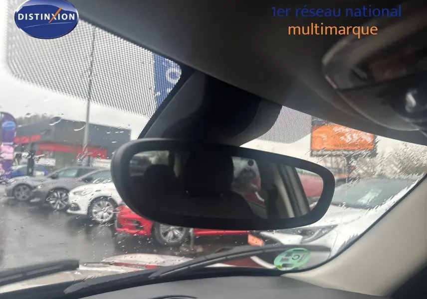 Vue intérieure du rétroviseur central d'une MINI 1.5 136CH grise, avec pluie visible sur le pare-brise.