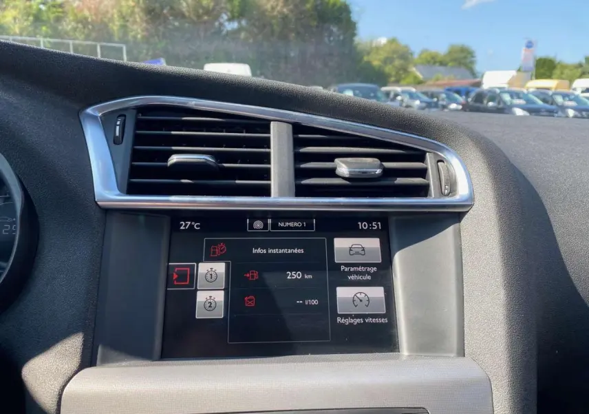 Écran tactile central du tableau de bord d'une Citroën C4 2015, avec commandes de climatisation et réglages affichés.