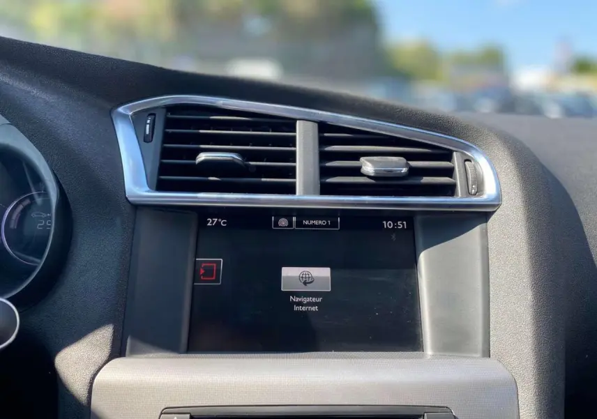 Tableau de bord de Citroën C4 2015 avec écran tactile et aérateurs centraux, vue intérieure rapprochée.