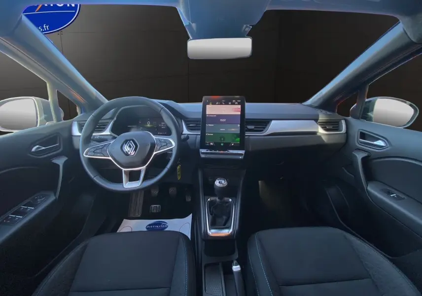 Intérieur du Renault Captur TCE 90 Evolution 2024, vue frontale du tableau de bord avec écran tactile vertical et levier de vitesses manuel.