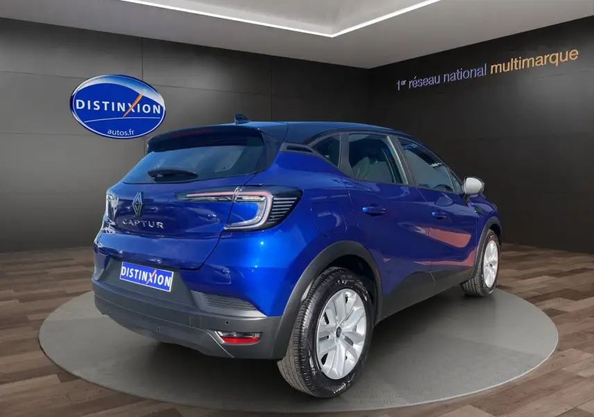 Vue 3/4 arrière droite du Renault Captur TCE 90 Evolution 2024 en bleu Iron avec toit noir et caméra intégrée.
