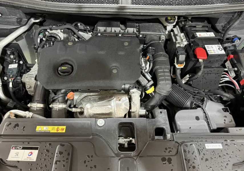 Vue rapprochée du moteur diesel gris sous le capot ouvert du Peugeot 5008 BlueHDi 130 S&S EAT8 Allure Pack 2021.