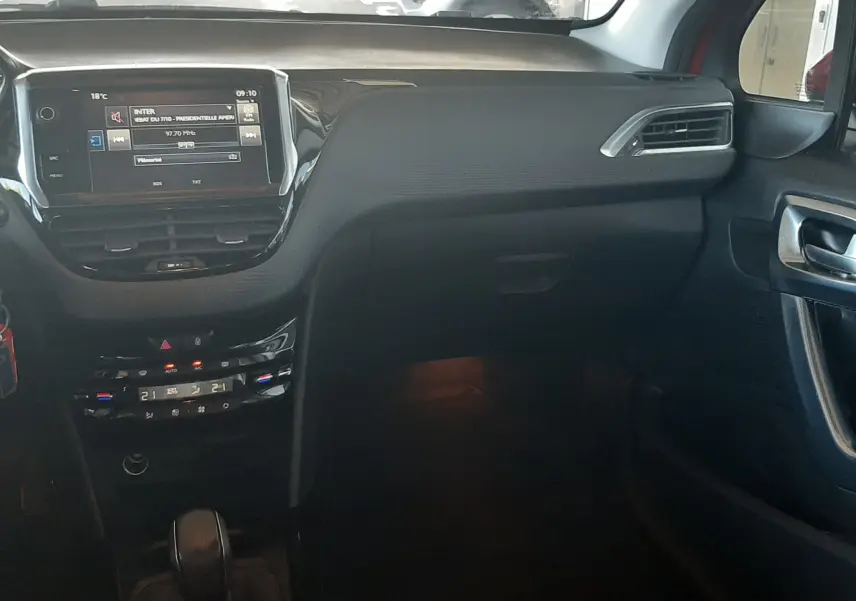 Vue intérieure côté passager du tableau de bord noir du Peugeot 2008 2016 avec écran tactile et commandes climatisation.
