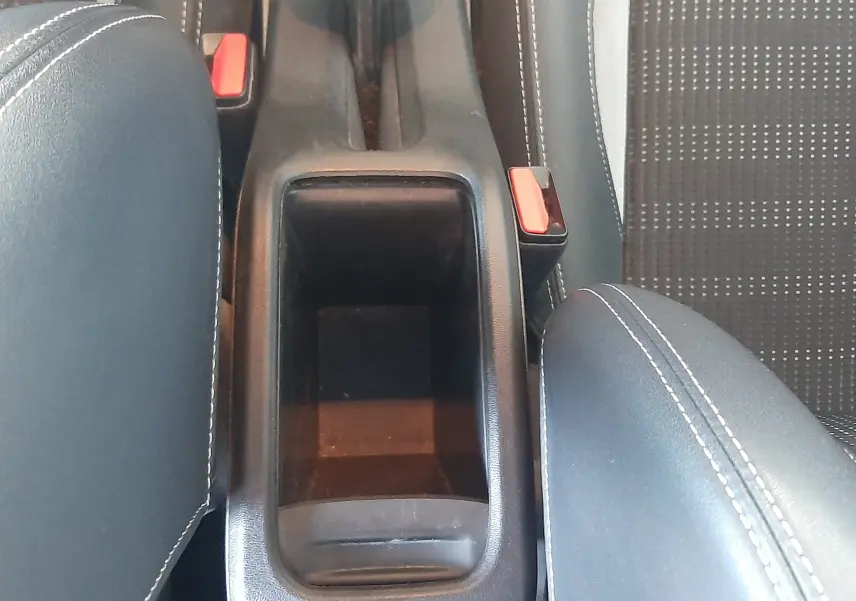 Vue plongeante sur la console centrale noire et les sièges tissu noir avec surpiqûres blanches du Peugeot 2008 rouge 2016