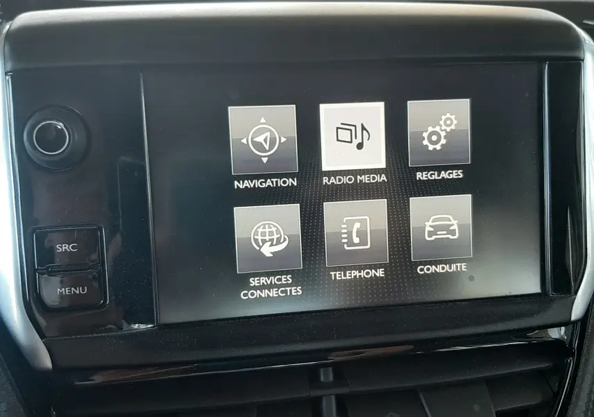 Écran tactile central du tableau de bord du Peugeot 2008 rouge, affichant les menus navigation, radio, réglages et téléphone.