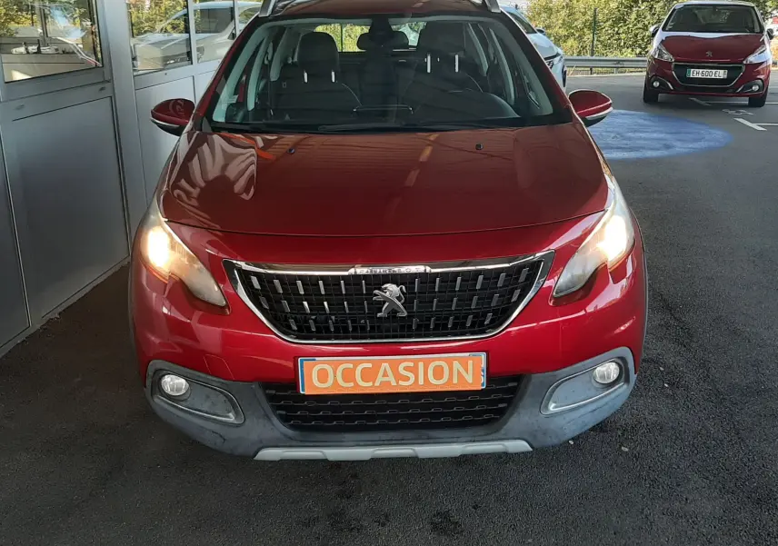 Vue avant d'un Peugeot 2008 rouge 2016 avec phares allumés et plaque "OCCASION" visible au centre.