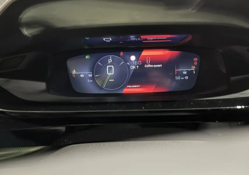 Combiné numérique 10 pouces de la Peugeot 308 GT 2024 affichant vitesse, jauge et alerte coffre ouvert.