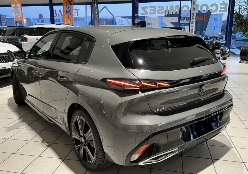 Vue 3/4 arrière droit d'une Peugeot 308 gris sélénium avec feux arrière LED griffés et jantes alliage 18 pouces.