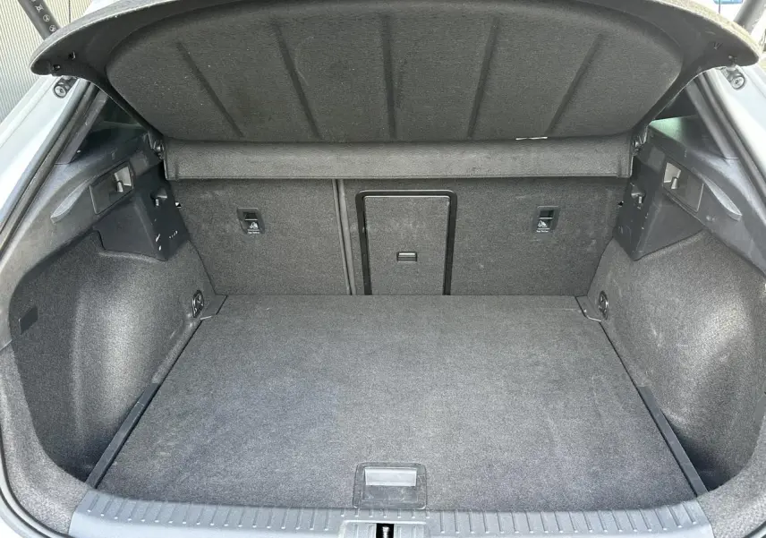 Coffre ouvert vu de l'arrière du CUPRA Formentor blanc Neige, intérieur de coffre en tissu gris.