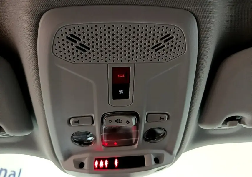 Vue en contre-plongée du plafonnier gris avec bouton SOS et éclairage intérieur rouge du Peugeot 2008 blanc 2021.