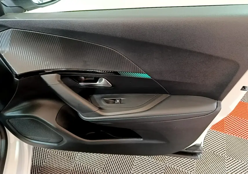 Vue intérieure côté gauche de la porte avant blanche du Peugeot 2008 avec insert décoratif et commande de vitre.