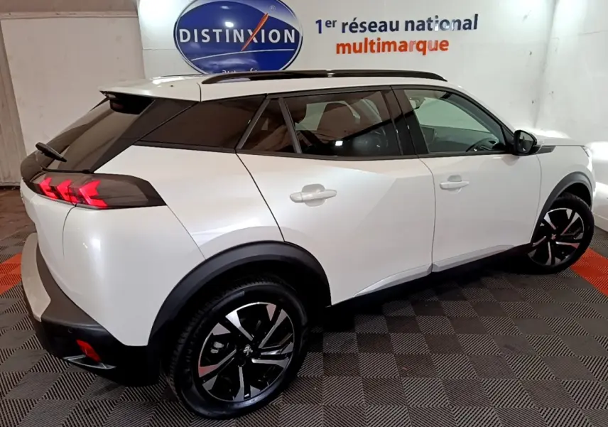 Vue 3/4 arrière droite du Peugeot 2008 blanc avec toit noir et feux arrière LED en forme de griffes.