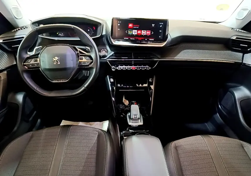 Vue intérieure avant du Peugeot 2008 2021, tableau de bord moderne avec écran tactile et volant cuir multifonctions.