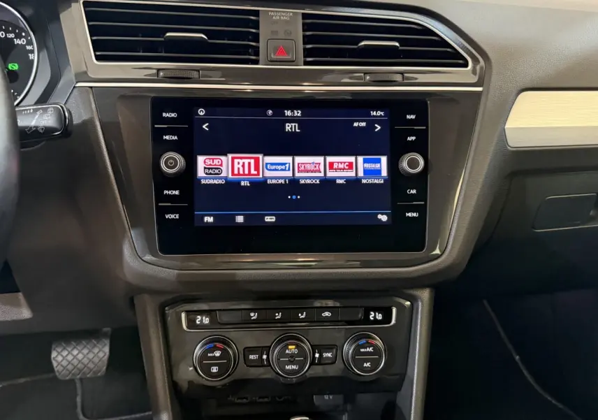 Vue rapprochée du tableau de bord du Volkswagen Tiguan 2020 gris clair, avec écran tactile central et commandes climatisation.