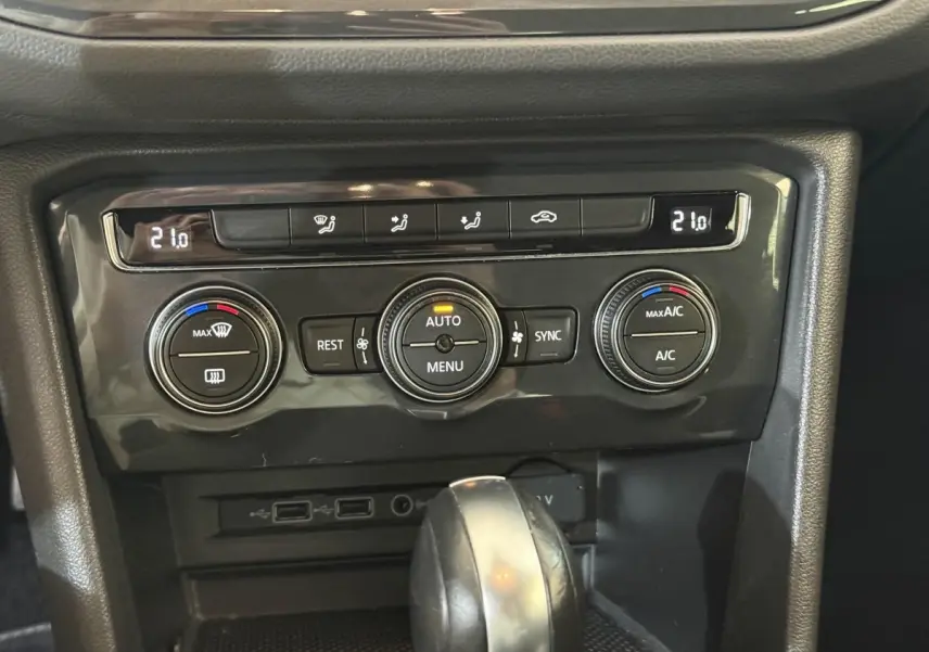 Gros plan sur la console centrale du Volkswagen Tiguan 2020, montrant les commandes de climatisation et le levier de vitesse.