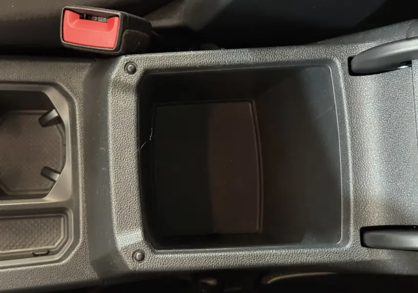 Gros plan sur le rangement central noir entre les sièges avant du Volkswagen Tiguan 2.0 TDI 150 DSG7 Confortline Business.