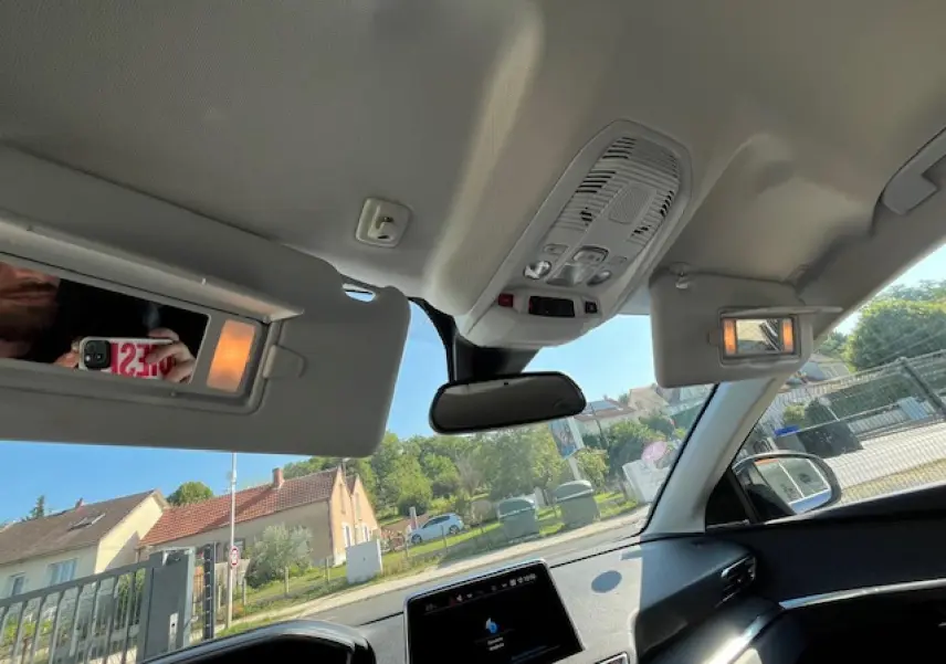 Vue intérieure du Peugeot 3008 2016 montrant les pare-soleil avec miroirs éclairés et le toit clair en plein jour.