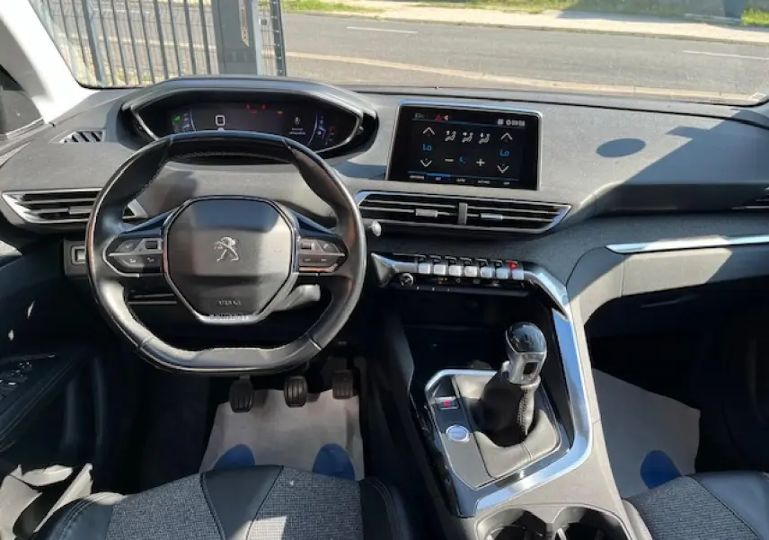 Intérieur du Peugeot 3008 2016 vu de face, volant compact, écran tactile et levier de vitesse manuel visibles.